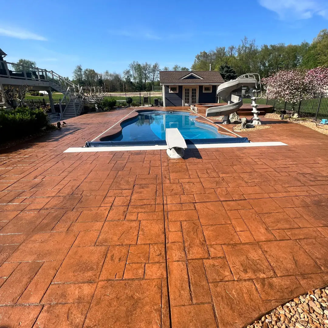 Stained concrete patio in front of a pool with a clear blue sky Stained concrete patio in front of a pool with a clear blue sky