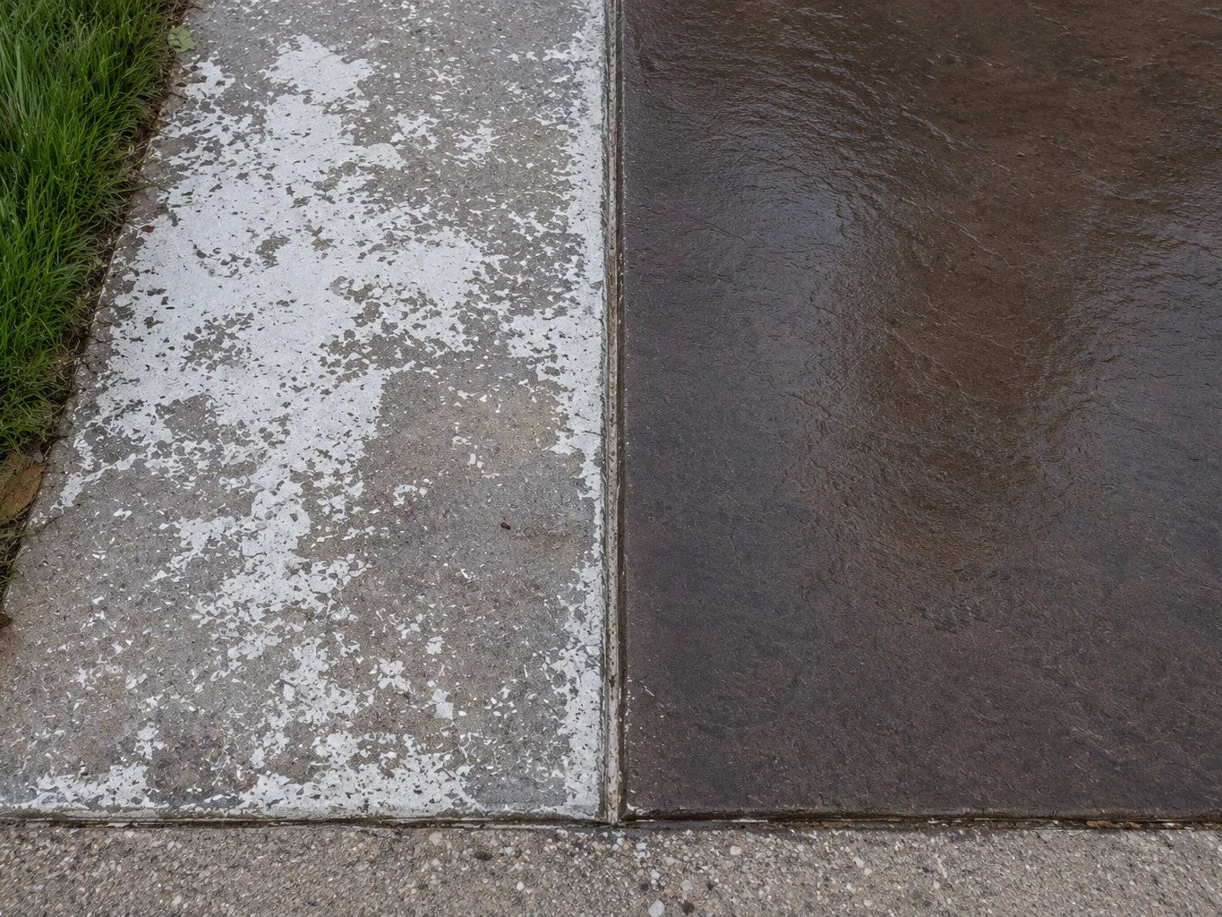 A failed concrete sealer peeling white and blotchy beside a smooth, evenly sealed dark stamped section