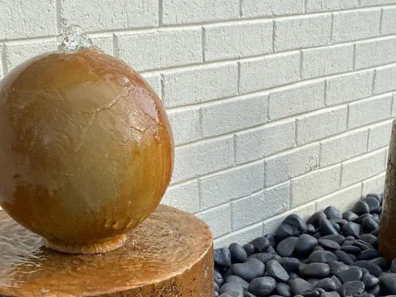Acid stained concrete water fountain in a garden setting