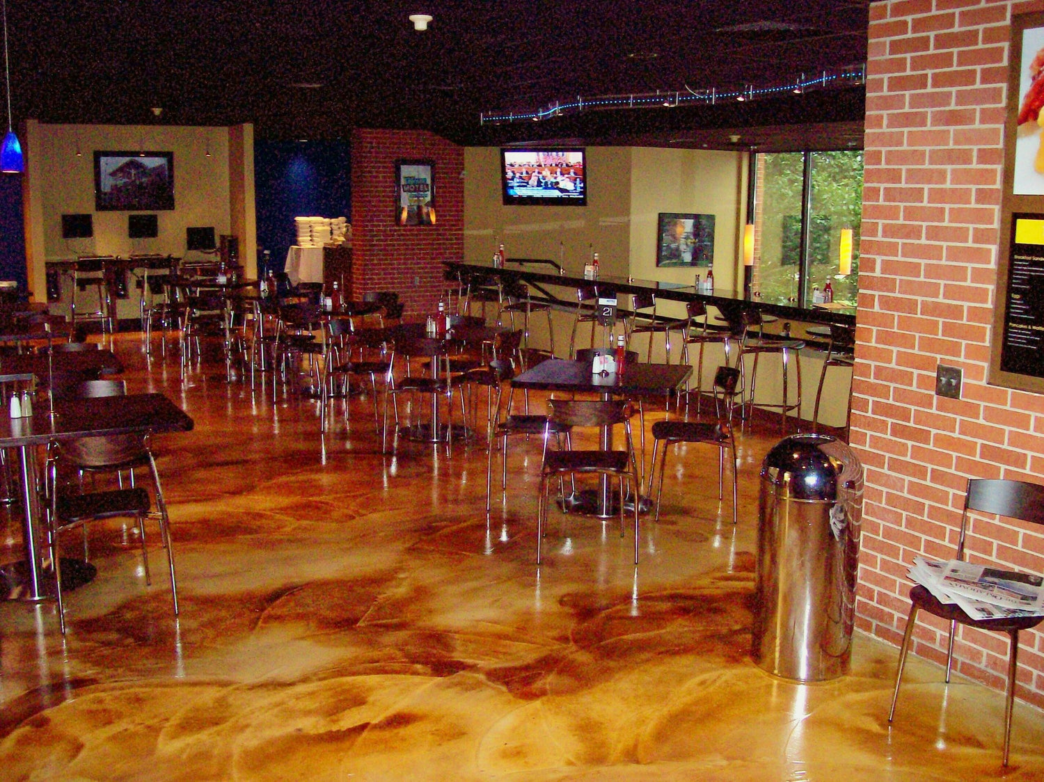 A restaurant floor resurfaced with a swirl finish concrete overlay and acid stained in Malayan Buff