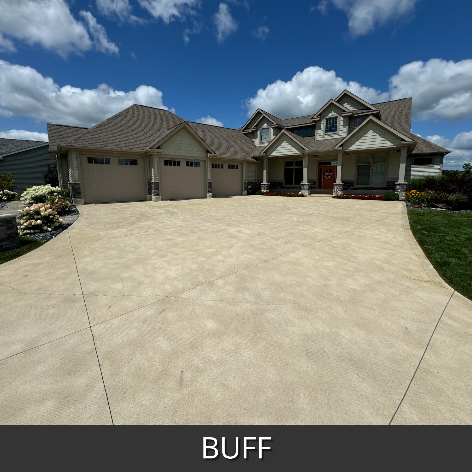 Large house with a driveway stained with buff antiquing stain labeled 'BUFF' under a blue sky with clouds