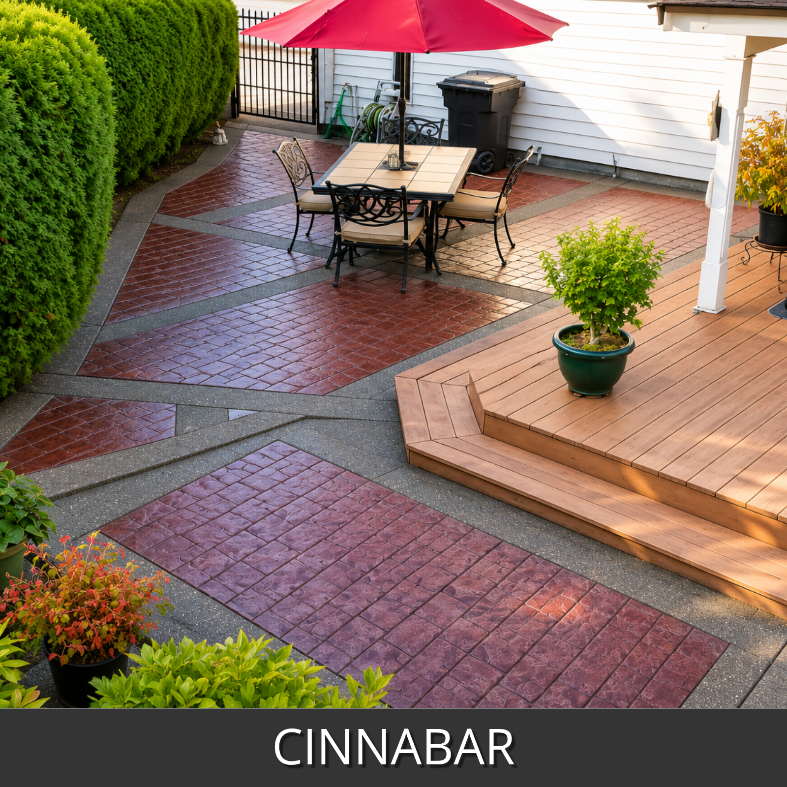 A landscaped outdoor patio and deck area with cinnabar colored brick pavers, shown in a real residential setting with tables, chairs, a red umbrella, plants, and a wooden deck.