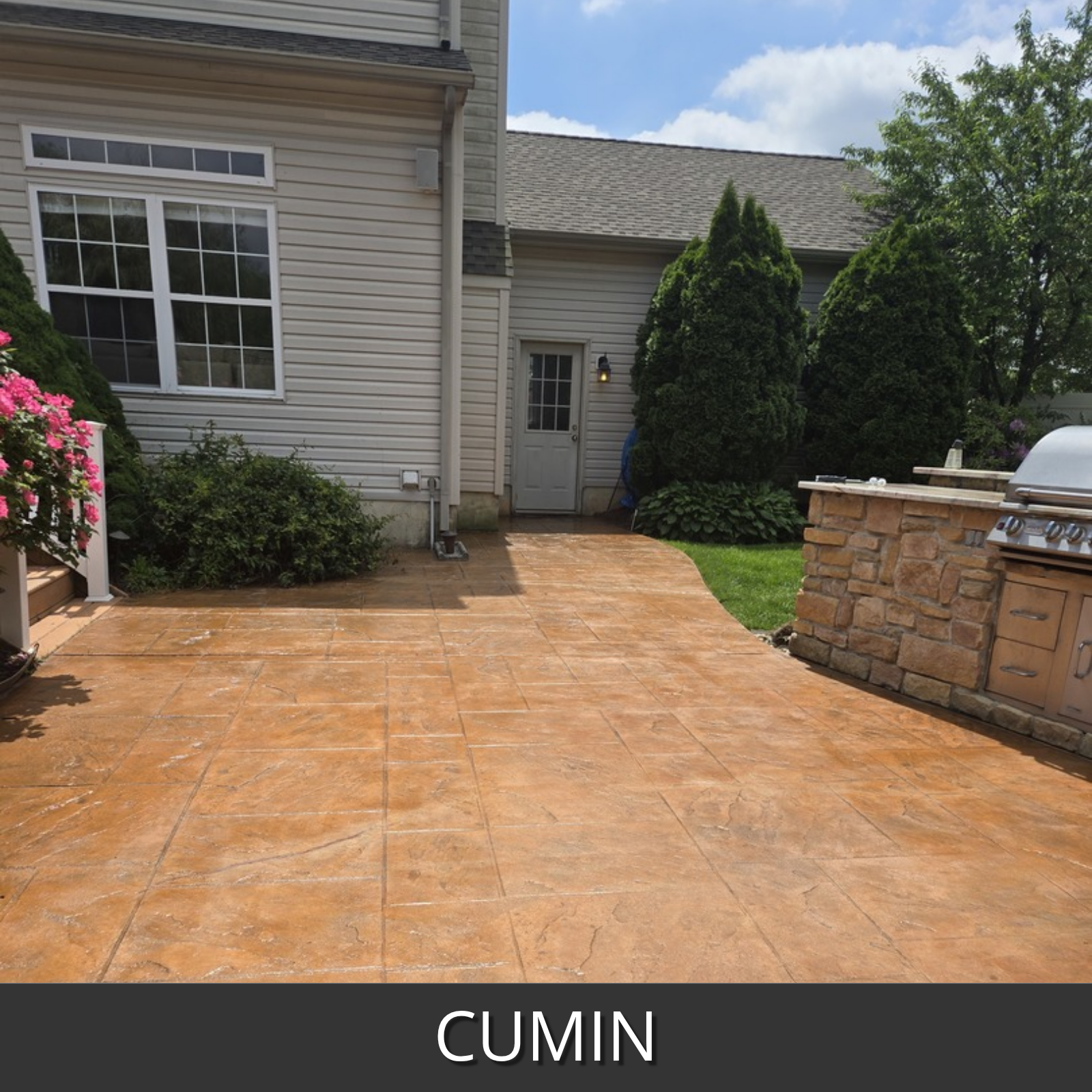 A large outdoor patio deck in a residential backyard, featuring a cumin-colored stamped concrete paver surface