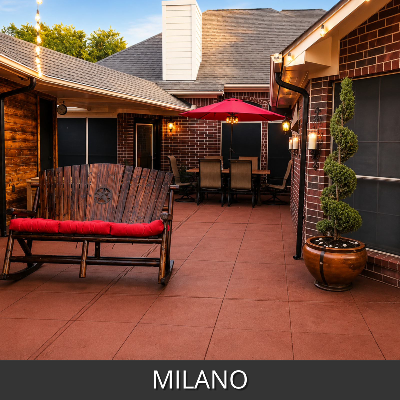 Milano red colored outdoor concrete paving tiles installed on a patio, shown in a backyard setting with a wooden bench, brick walls, an umbrella, and a potted tree