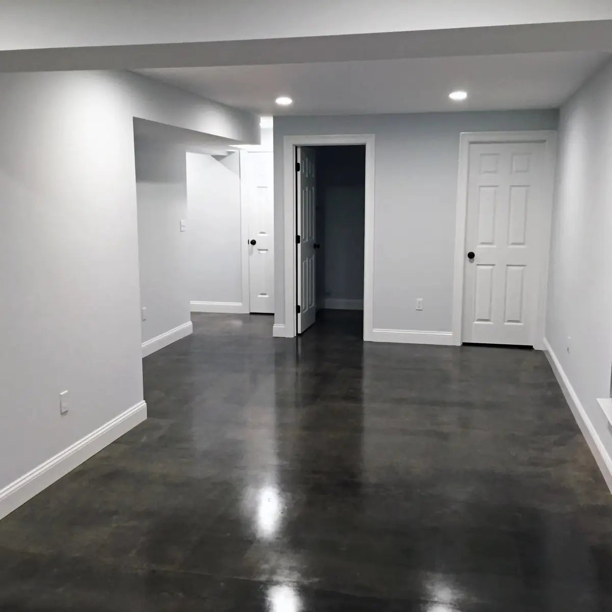 Sealed concrete floor in an empty finished basement, AcquaTint™ PRO Colored Sealer in 506 Charcoal