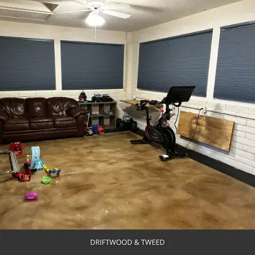 Sealed concrete floor in a home gym with a sofa and exercise bike, AcquaTint™ PRO Colored Sealer in Driftwood and Tweed