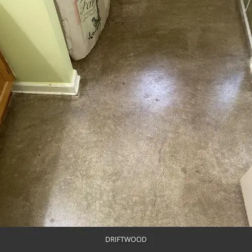 Sealed concrete floor in a room with a baseboard and pale green wall, AcquaTint™ PRO Colored Sealer in 511 Driftwood