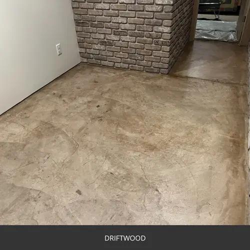 Sealed concrete floor in a room with an exposed brick chimney, AcquaTint™ PRO Colored Sealer in 511 Driftwood
