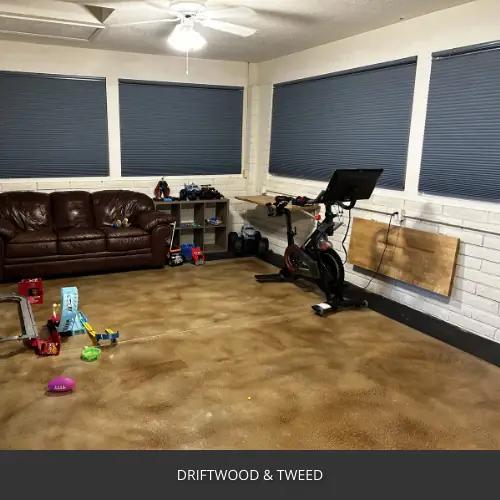 Sealed concrete floor in a home gym with a sofa and exercise bike, AcquaTint™ PRO Colored Sealer in Driftwood and Tweed