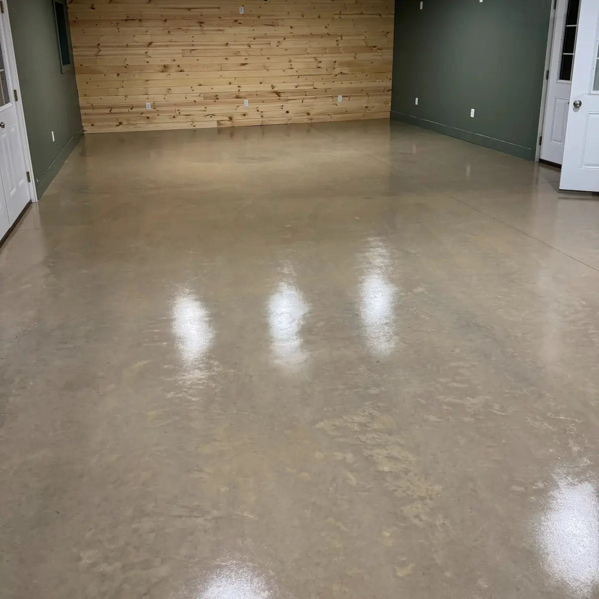 Sealed concrete floor in a room with a wood accent wall, AcquaTint™ PRO Colored Sealer in 516 Khaki