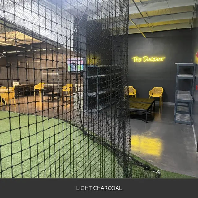 Sealed concrete floor in an indoor batting cage and lounge area, AcquaTint™ PRO Colored Sealer in 517 Light Charcoal