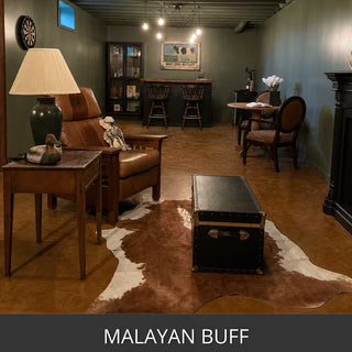 Acid stained concrete floor in a den with a leather sofa and a cowhide rug, EverStain™ Acid Stain in MAB Malayan Buff