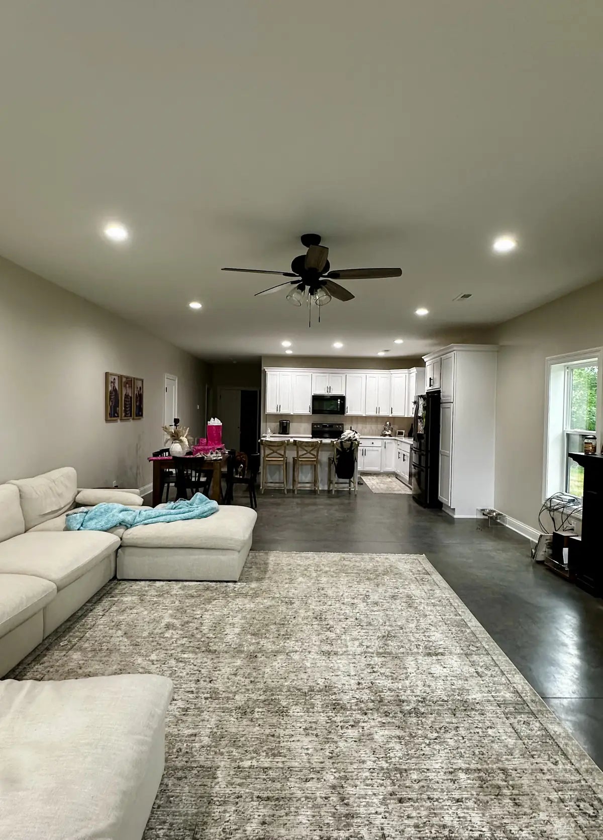 Smooth dyed concrete barndominium floor in an open living room, sealed with AcquaSeal™ and ProWax Polish™, Vibrance™ Concrete Dye in Charcoal, Light Slate, Stormy Gray and White