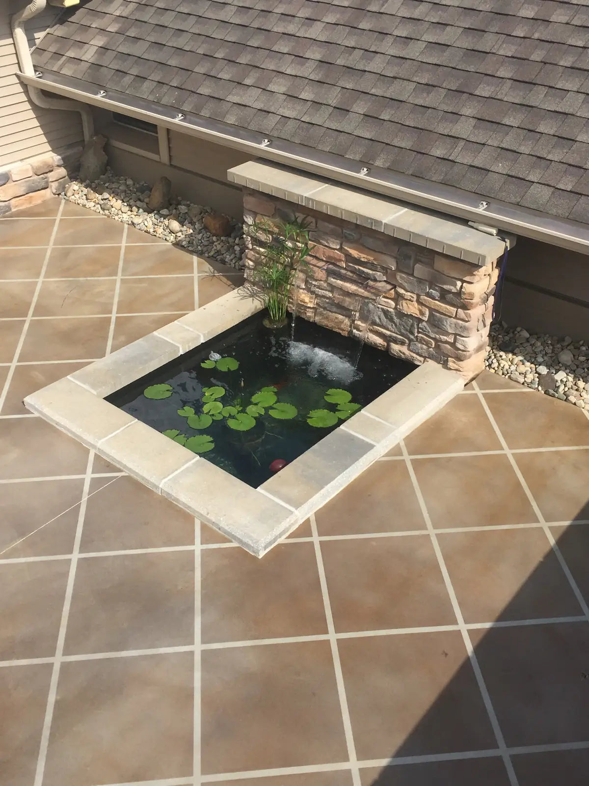 Dyed concrete patio with a tiled pond surround and stone planter, Vibrance™ Concrete Dye in Charcoal, Khaki, Tweed and Stormy Gray