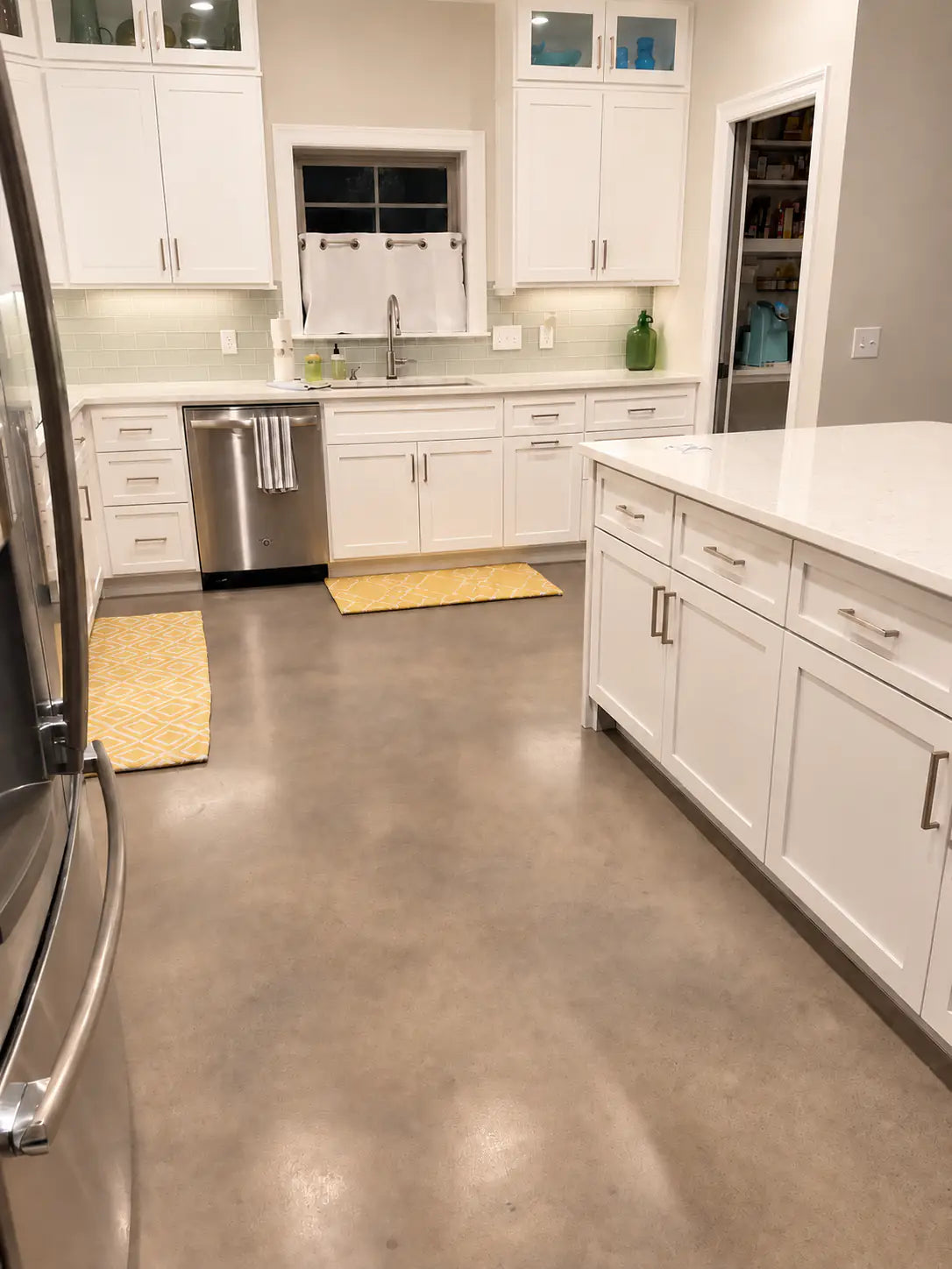 Dyed concrete kitchen floor with white cabinets and a stainless refrigerator, Vibrance™ Concrete Dye in Charcoal, Light Slate, Stormy Gray and White