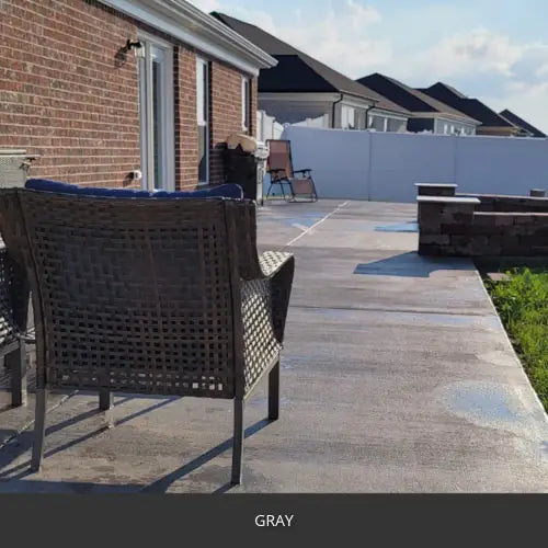 Sealed concrete patio with a wicker chair and a privacy fence, EasyTint™ Tinted Concrete Sealer in 515 Gray