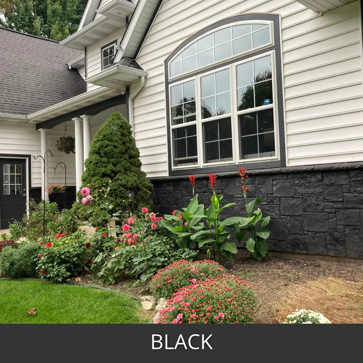 Stained stone veneer foundation wall beside a garden bed, Portico™ Paver Stain in 703 Black