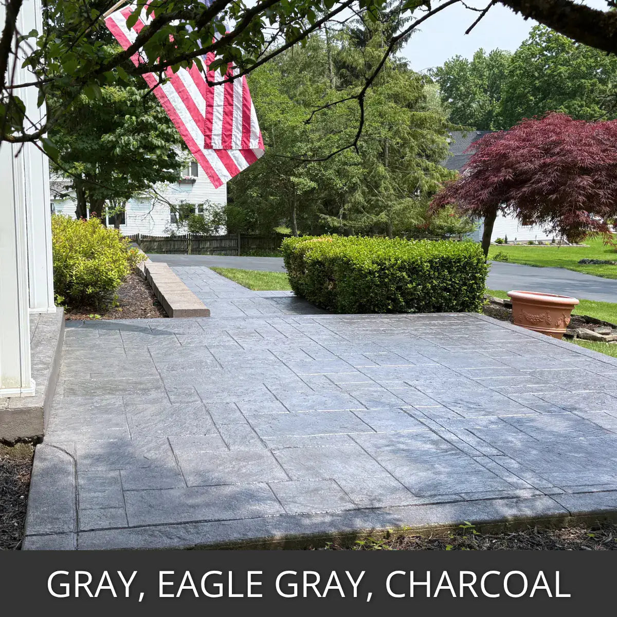 Stained concrete patio in a front yard with a flag pole, Portico™ Paver Stain in Gray, Eagle Gray and Charcoal
