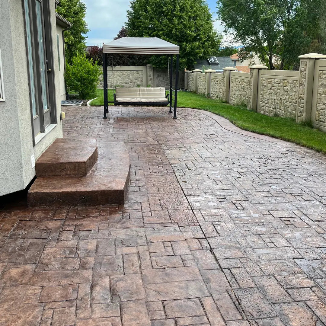 Paved patio with a gazebo and bench in a residential backyard