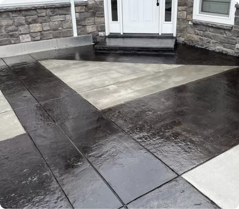 Decorative stone patio with a geometric pattern in front of a house