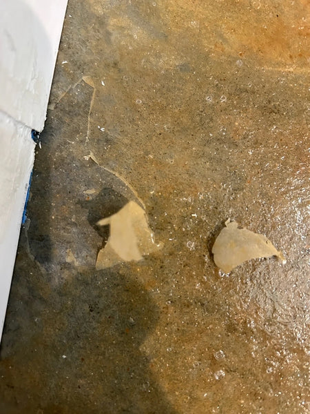 Acid stain sealer peeling and flaking off a concrete floor because residue was not removed before sealing