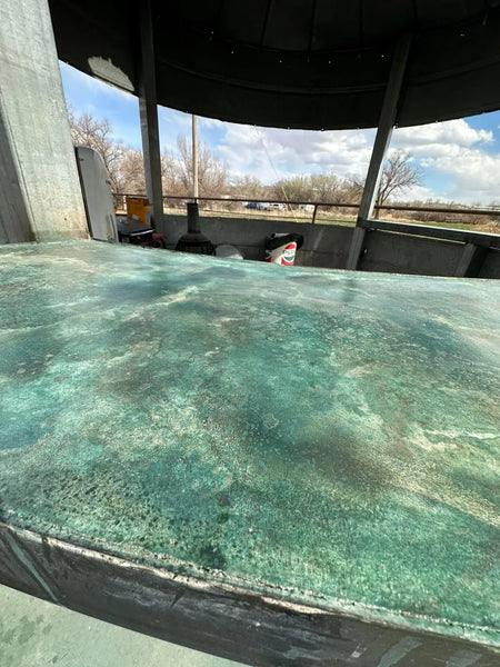Finished turquoise acid-stained concrete grain-bin bar on a stained patio