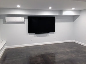 Renovated basement room with a TV, showcasing the gleaming floor finish