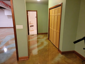 A close-up view of the sealed and waxed stained concrete basement floor, showing a lustrous finish