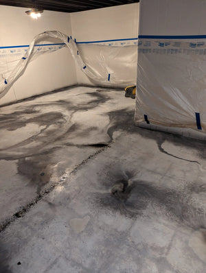 Image showcasing the basement floor after applying white and Steel ColorWave stains, creating a marble-like veining design