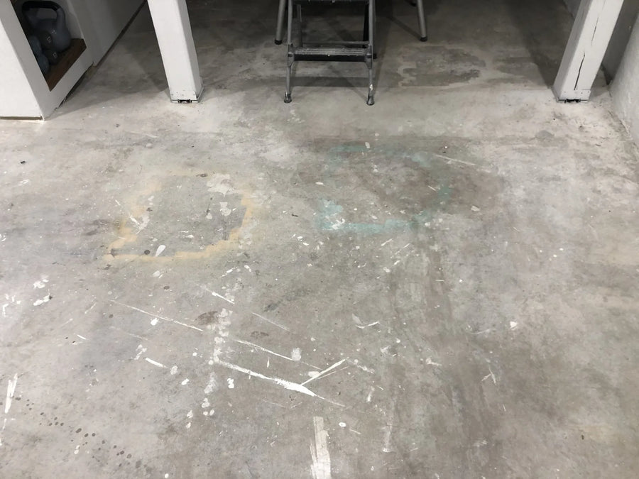 Basement floor with old stains, spray paint and overspray on it