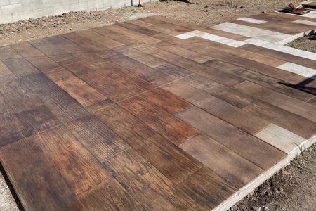 Sealed wood-plank stamped concrete colored with Coffee Brown Vibrance dye and Charcoal Black Antiquing grain
