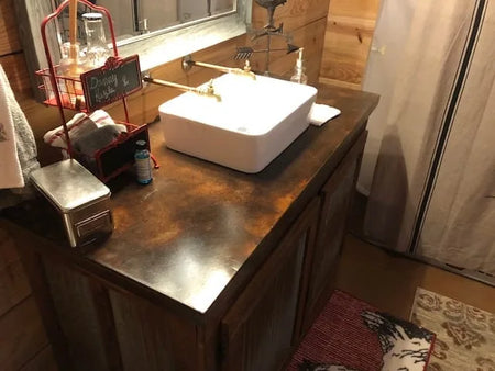 Elevating the rustic theme with this concrete vanity, perfectly stained with Coffee Brown. A beautiful blend with the Malayan Buff and Desert Amber flooring