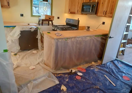 Smoothing out the edges of a concrete overlay covered countertop with sanding
