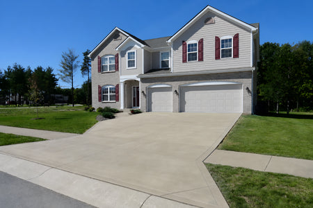 Broom-finished concrete driveway after applying Buff EasyTint colored sealer for a warm beige finish