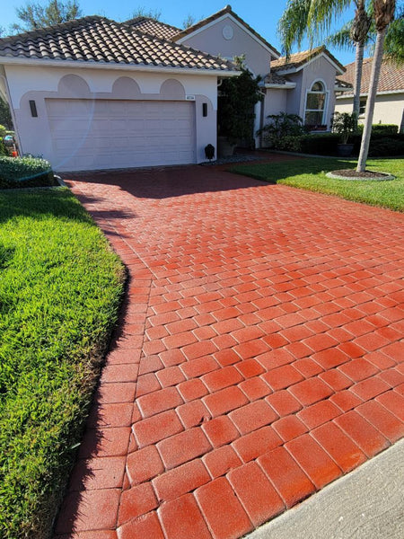 Front driveway with Crimson stained concrete pavers leading to a residential garage