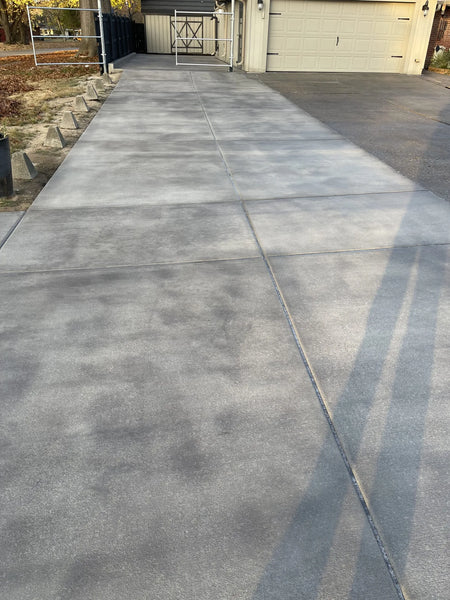 Broomed concrete driveway after being stained with Light Charcoal Antiquing, showing a rich and even color enhancement