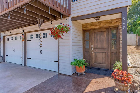 Front entryway and garage featuring two-tone stained concrete in Aztec Brown and Sunset Tan with clean detailing and vibrant curb appeal