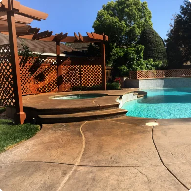 Outdoor setting with a pool, hot tub, and pergola on a sunny day