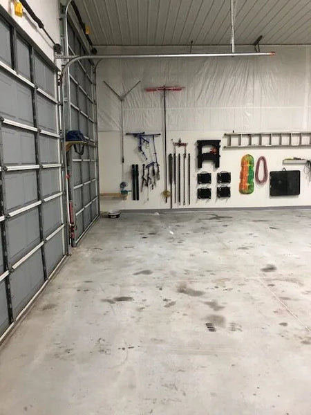 Before photo of a barn shop floor with visible oil stains and wear