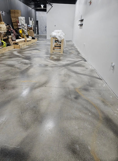 Artistically applied swirls of Charcoal AcquaTint and Mica highlights on the concrete salon floor
