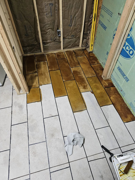Applying Coffee Brown EverStain™ to the taped-off concrete floor