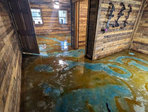 Acid stain applied with vibrant blue and amber tones on the shop floor, showing the wet application stage