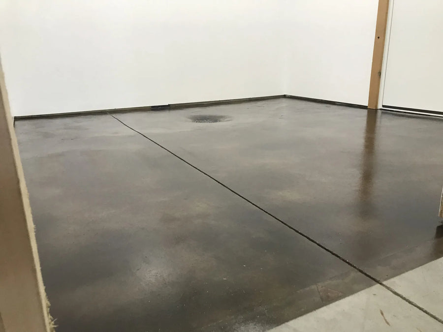 The renovated mechanical room with a black acid-stained floor exhibiting brown hues, sealed with a satin finish