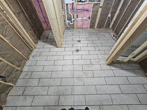 Concrete floor with duct tape neatly arranged following the chalked tile pattern