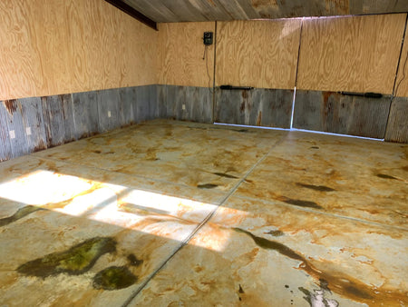 A concrete floor freshly sprayed with Avocado and Malayan Bluff acid stains from EverStain, showing a raw and unsealed look
