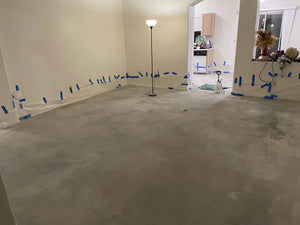 An image of a living room with bare, cleaned concrete floors, ready for the staining process