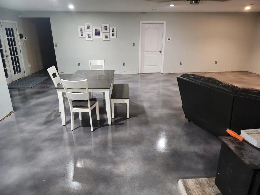 Living room with a faux polished concrete floor stained in stormy gray, charcoal, and white vibrance dye, featuring simple furniture