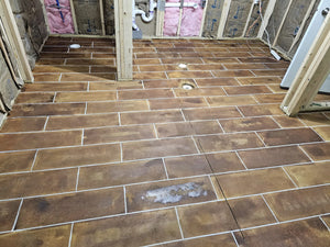 Revealing clean, crisp lines after removing the tape from the stained concrete floor