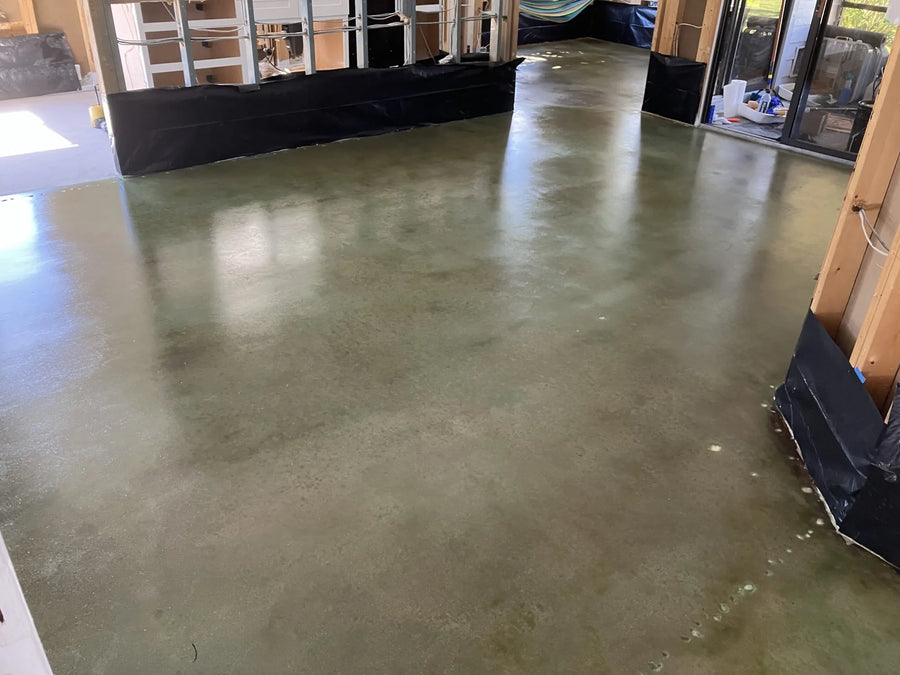 Image of a renovated home interior featuring a beautifully stained concrete floor in hues of Seagrass and Black