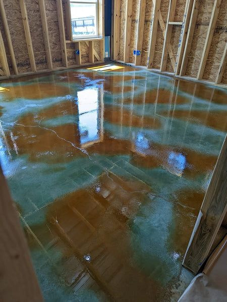 A photo of a concrete floor stained wet-on-wet with the Malayan Buff accent color over on Seagrass base color acid stain